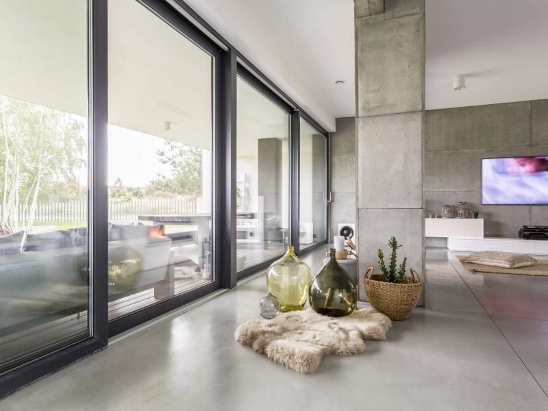 Giant column supporting the house standing next to a windowed wall